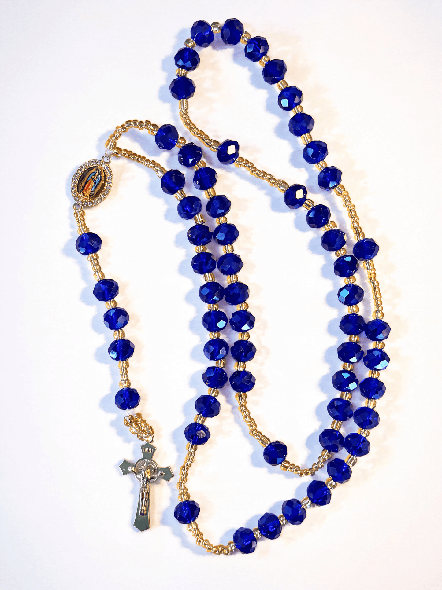 Blue rosary with gold accents on a white background