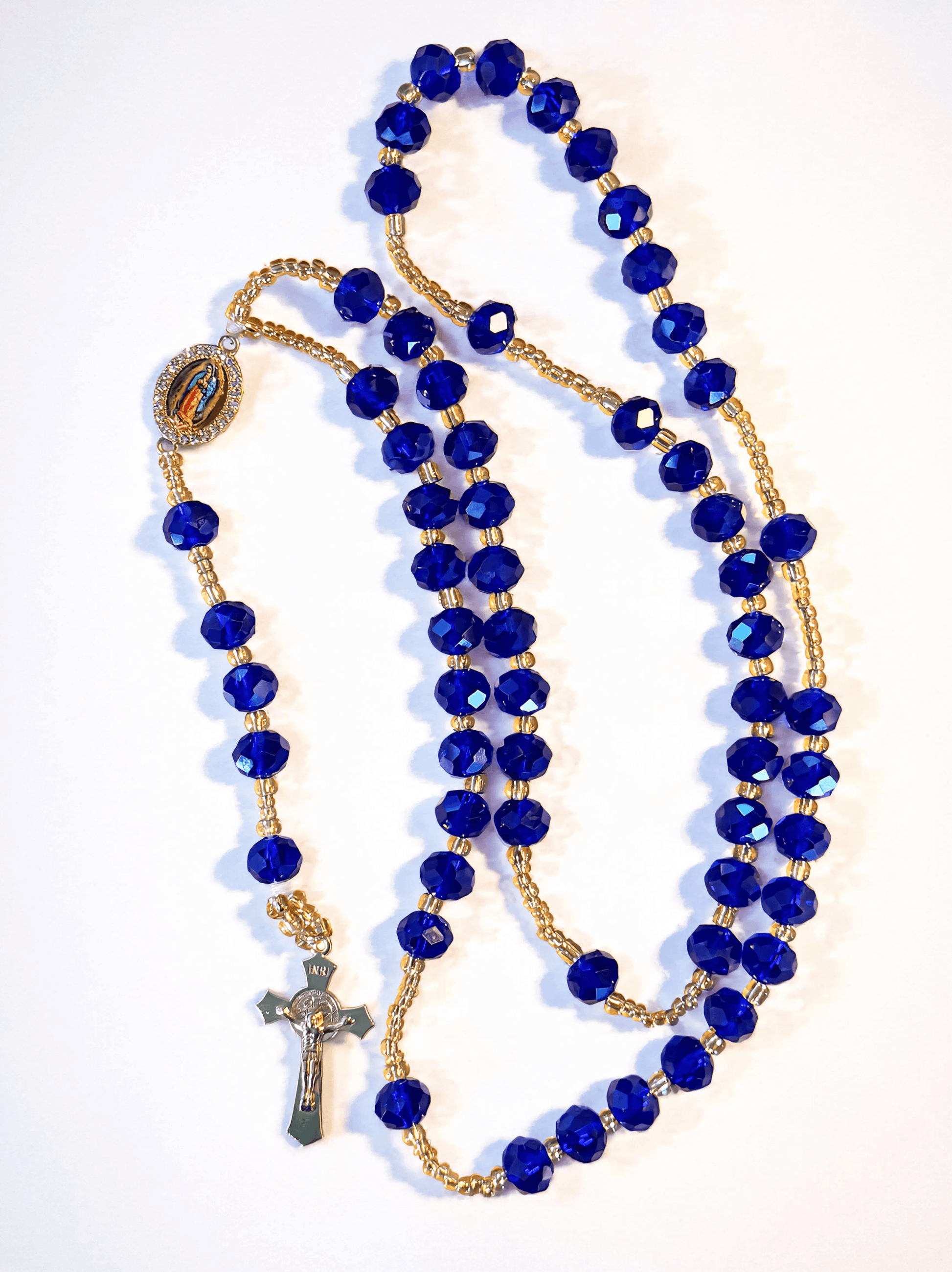 Blue rosary with gold accents on a white background